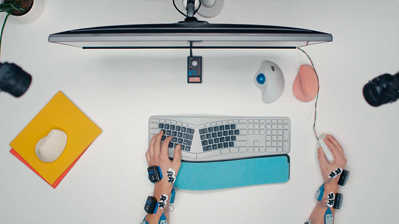 Tampilan atas seorang pengguna dengan lengan terhubung ke beberapa sensor sedang menguji keyboard dan mouse ergonomis