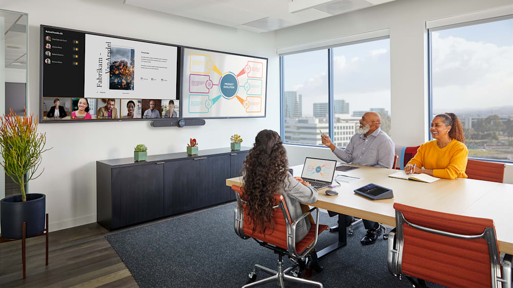 Three teammates hold a virtual meeting in conference room with Rally Bar camera.