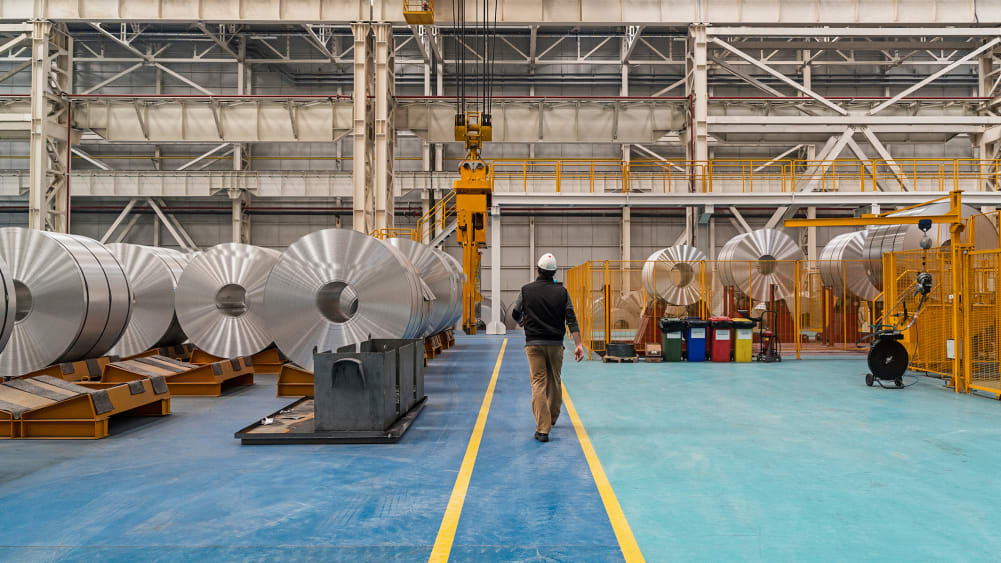 Worker walking through aluminum factory