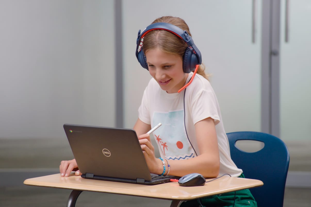 Elev som använder en chromebook med Logitech-headset och en digital penna