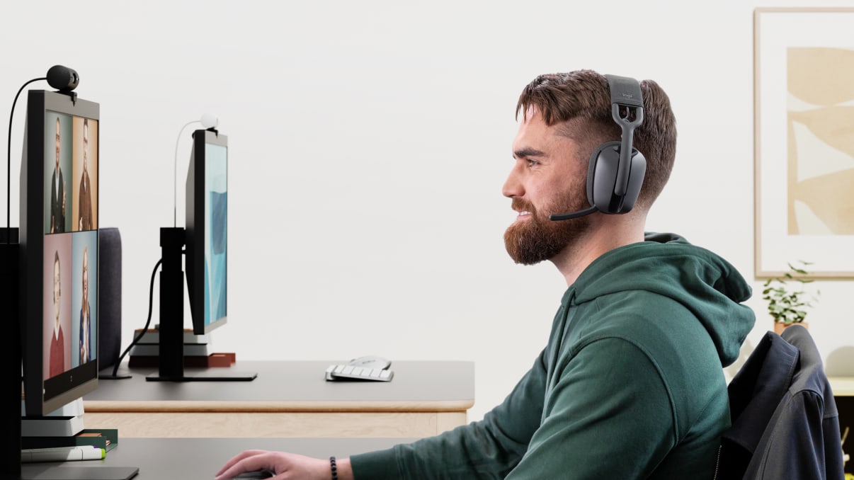 A man in a meeting with overhead zone vibe wireless headset