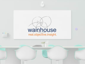 Logo Wainhouse superposé à une salle d’enseignement compatible Scribe