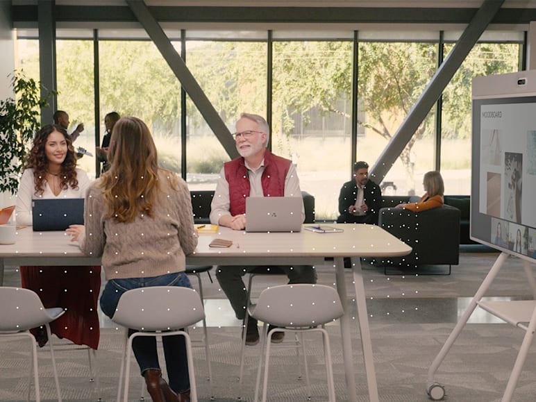 A team collaborates around a high-top table while using Logitech Rally Board 65.