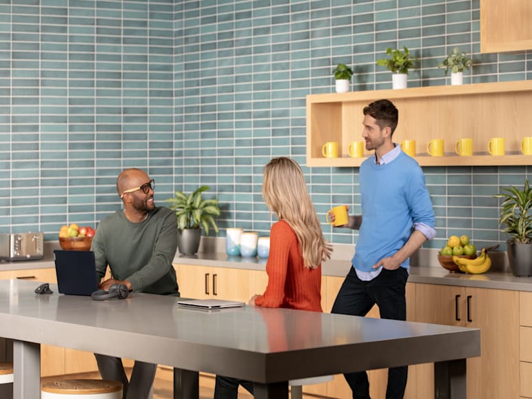 Three people in a kitchen setting, engaged in conversation