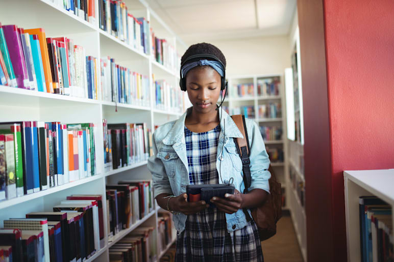 A student in library engaged in audio learning