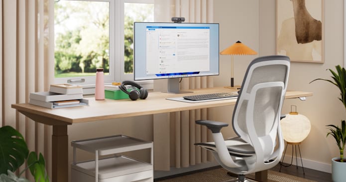 Otthoni irodai berendezés Logitech billentyűzettel, egérrel, webkamerával és fejhallgatóval, amelyet a Microsoft Teams hívásokhoz használnak.