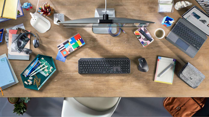 Man working on Mac with MX Keyboard and Mouse